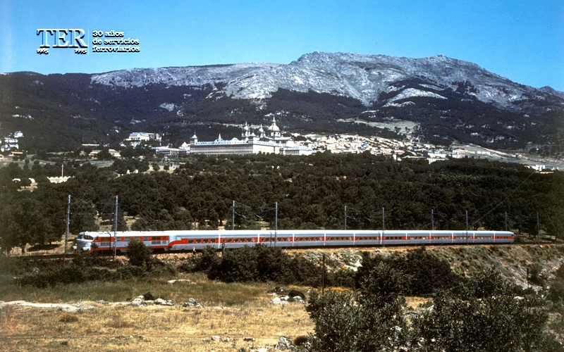 Composicin de Talgo III completa avanzando al pie de la Sierra de Guadarrama, con El Escorial al fondo